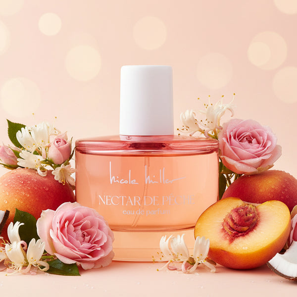 Bouteille de parfum Nectar de Pêche de Nicole Miller avec un liquide rose et orange.